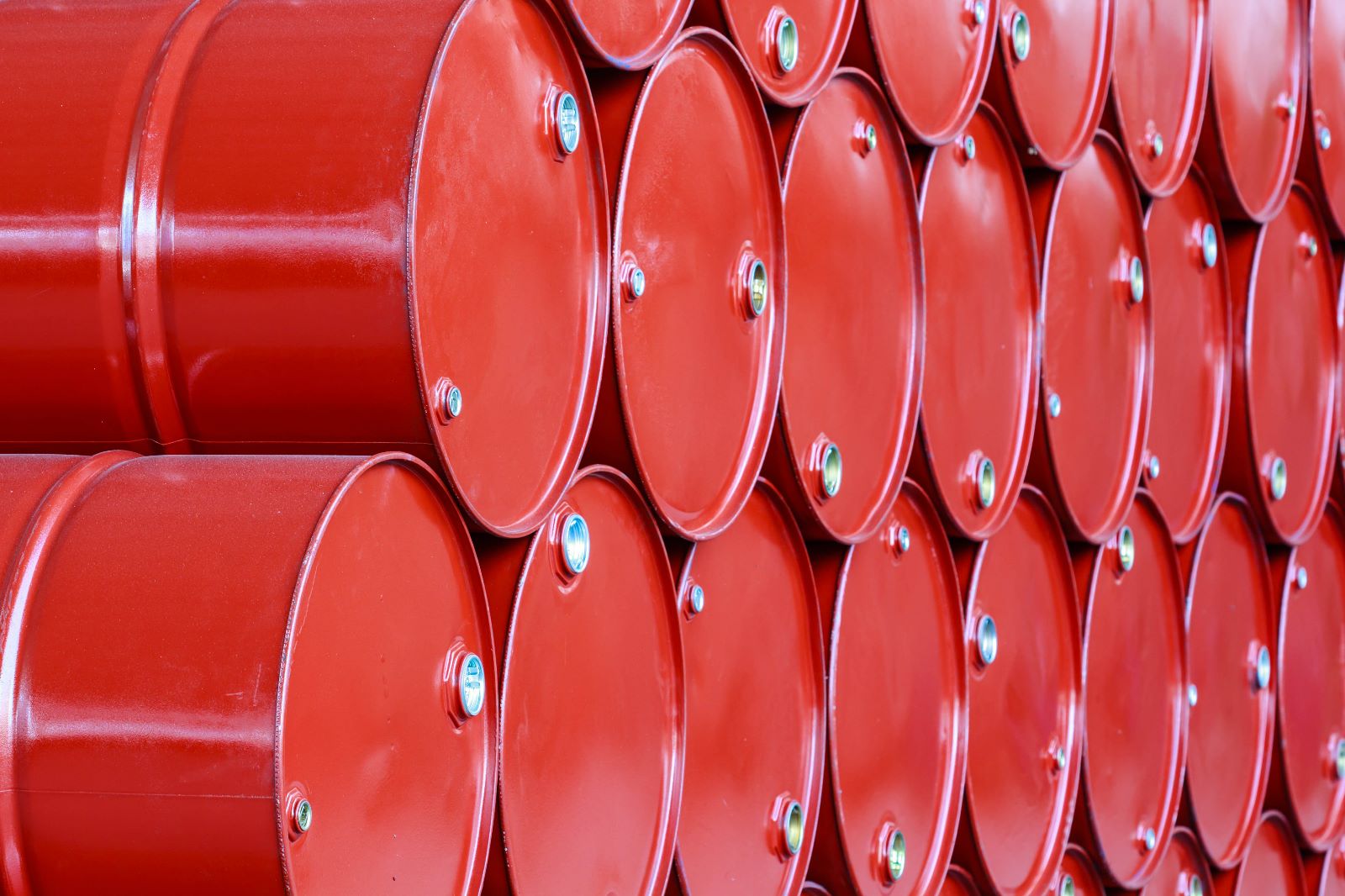 Rows of red industrial barrels stacked in an orderly fashion.